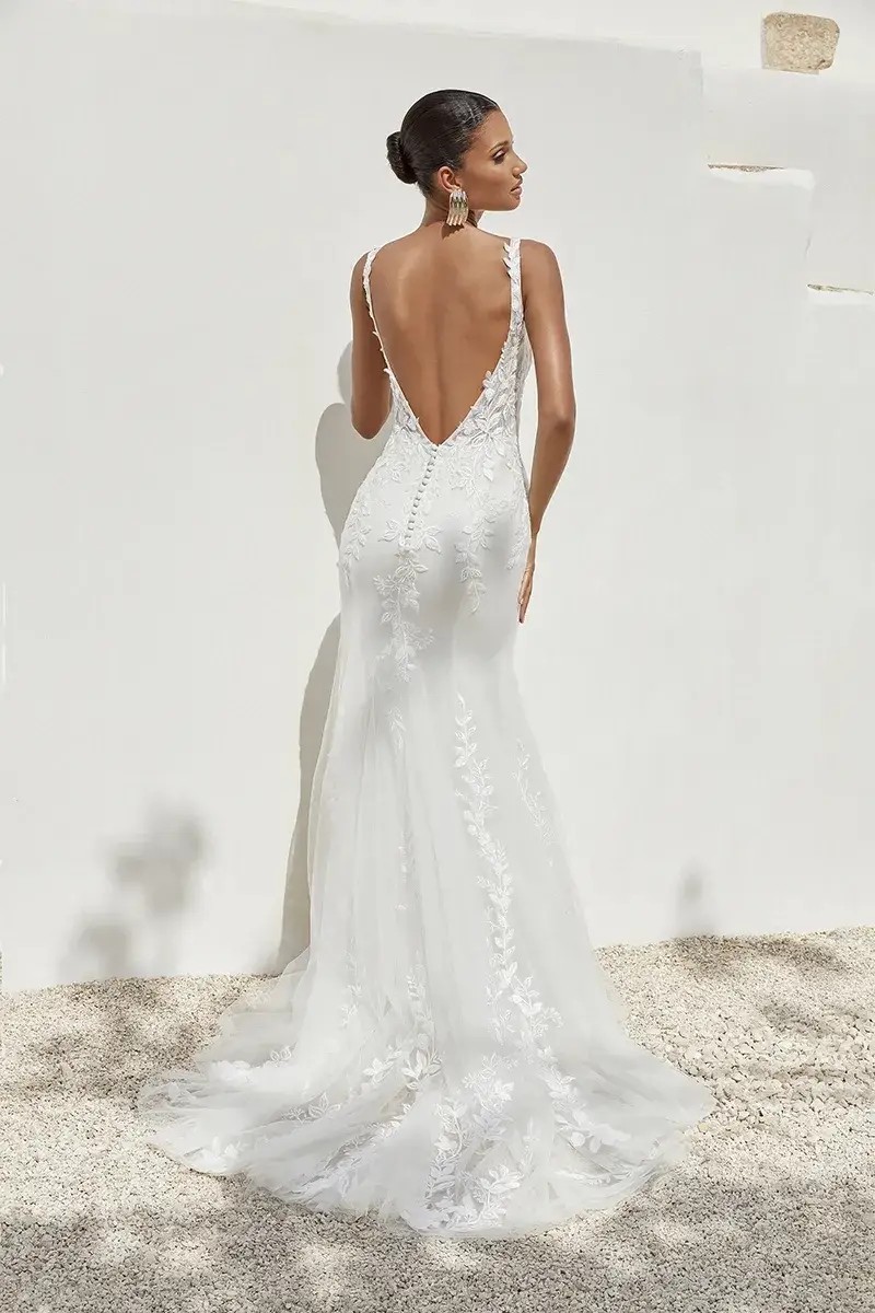 Model is wearing a fit and flare wedding dress with a plunging neckline and sheer bodice by justin alexander