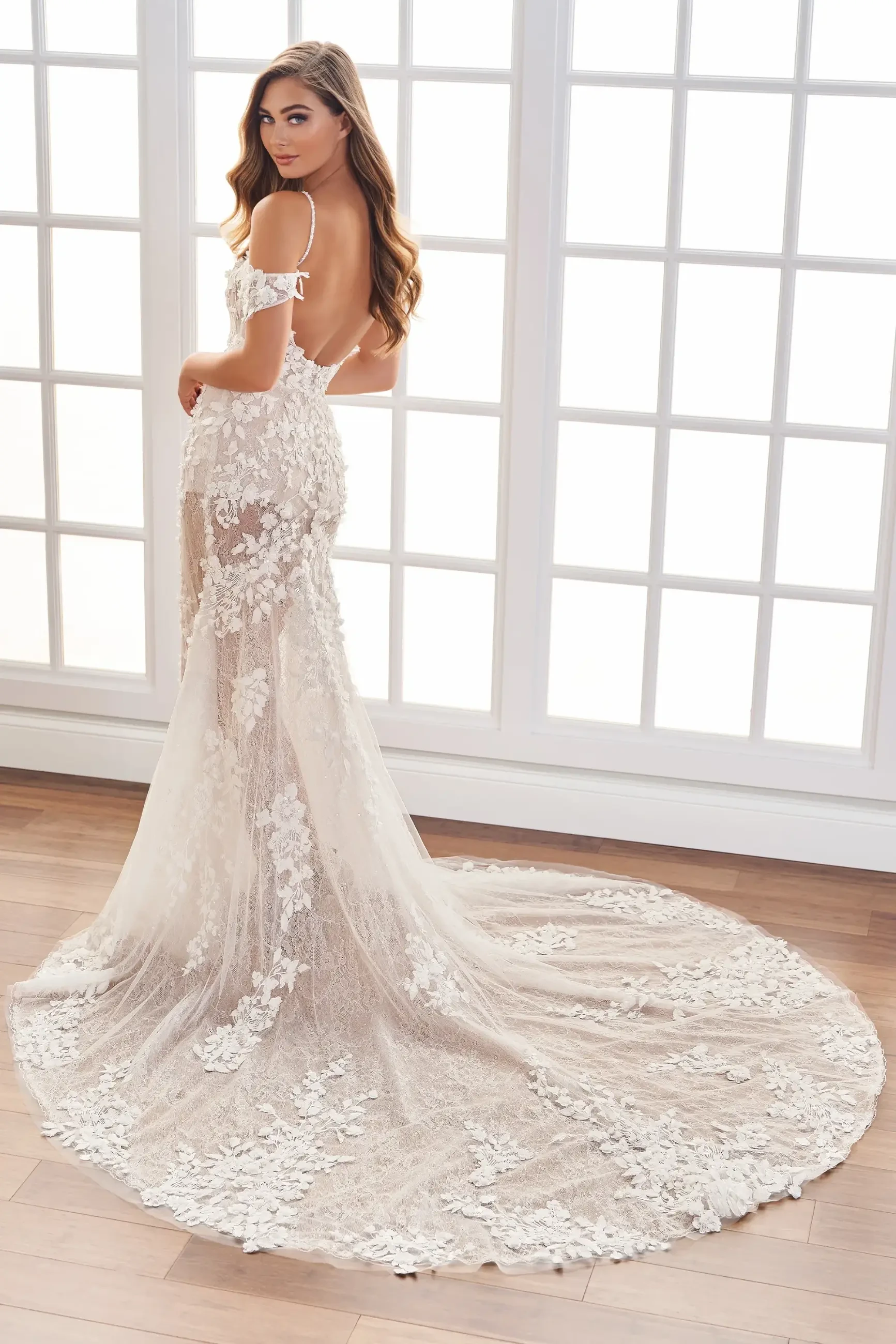 model is wearing an off the shoulder lace fit and flare bridal gown 