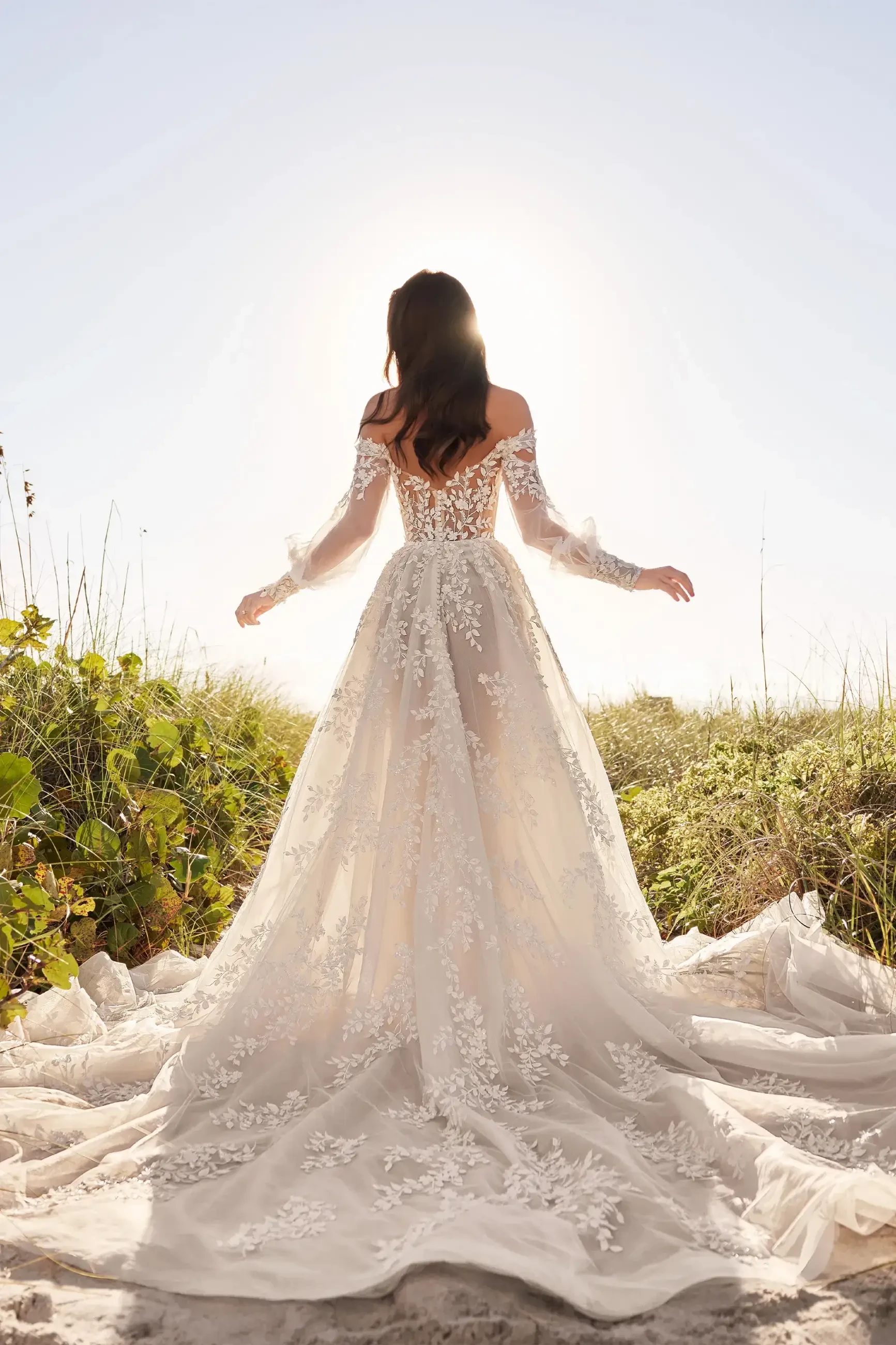 model is wearing an off the shoulder lace bridal gown by martin thornburg