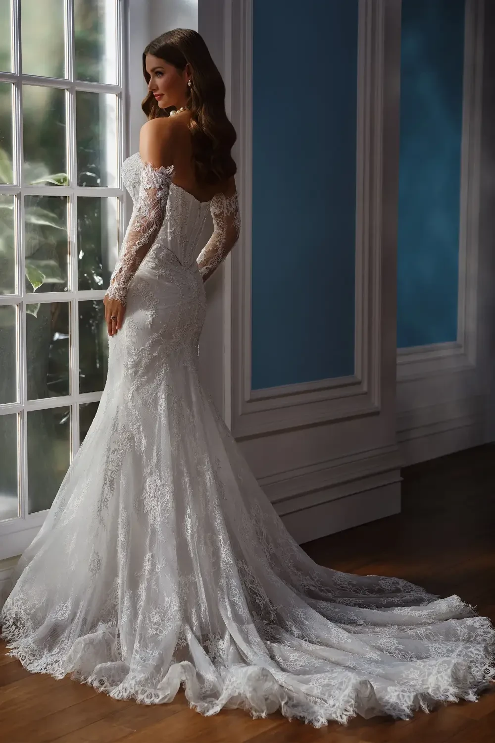 model is wearing an allover lace bridal gown with detachable off the shoulder long sleeves