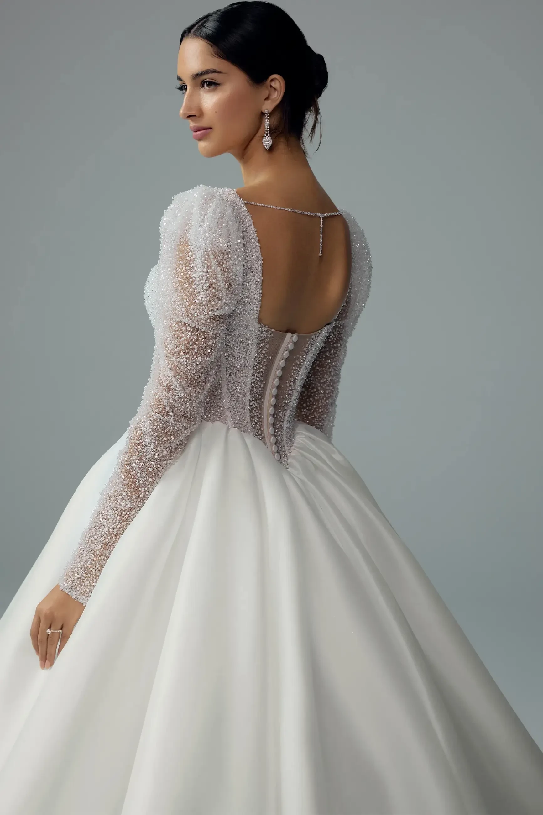 model is wearing a long sleeve ball gown wedding dress