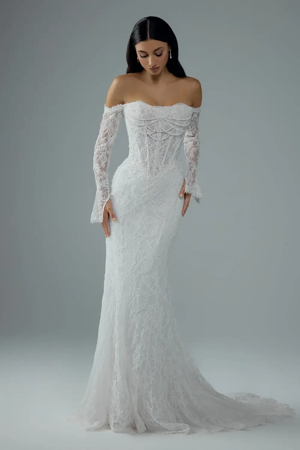model is wearing an off the shoulder long sleeve wedding dress