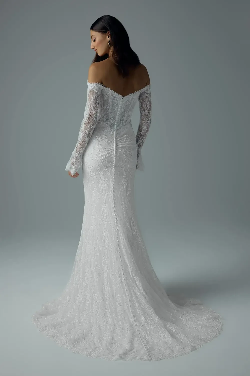 model is wearing an off the shoulder long sleeve wedding dress
